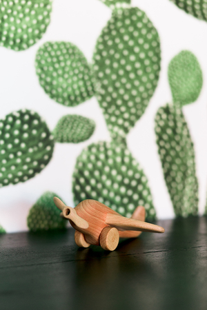 retro wood toy airplane on table with green cactus background.の写真素材