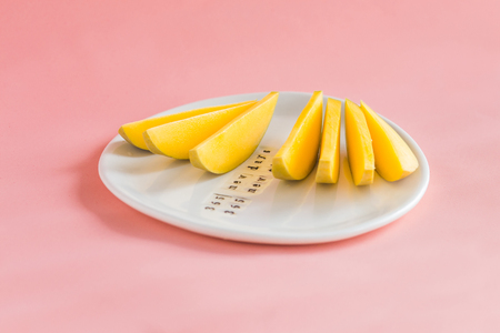 Mango fruit and mango slices on the white plate. Tropical fruit concept. plate motivationの写真素材