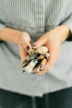girl potter's holds carving tools on ceramics in her studioの写真素材