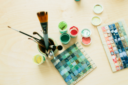 drawing tools in a ceramic glass and paints on a wooden tableの写真素材