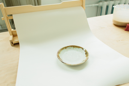 ceramic plate made on a Potter's wheel on a wooden table in the Studioの写真素材
