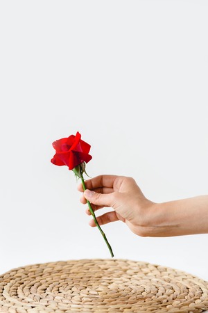 Coloful roses in vase on a nature wicker napkin on white backgroundの写真素材
