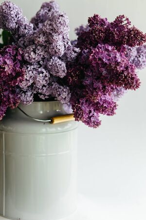 Beautiful purple bouquet of lilac flowers in a stylish vase on a white backgroundの写真素材