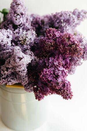 Beautiful purple bouquet of lilac flowers in a stylish vase on a white backgroundの写真素材