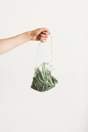 Reusable eco-friendly bag full of fresh seasonal pea pods . Taking care of the environment and abandoning the concept of plasticの写真素材