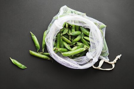 Reusable eco-friendly bag full of fresh seasonal pea pods . Taking care of the environment and abandoning the concept of plasticの写真素材