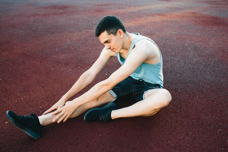 Young man doing outdoor exercise in new York. She is wearing a blue top and sport shortsの写真素材