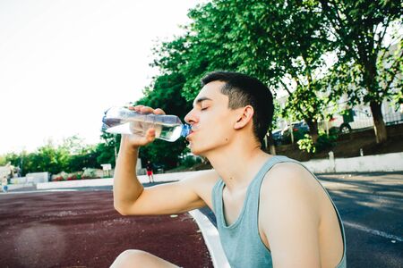 Young man doing outdoor exercise in new York. he is wearing a blue top and sport shortsの写真素材