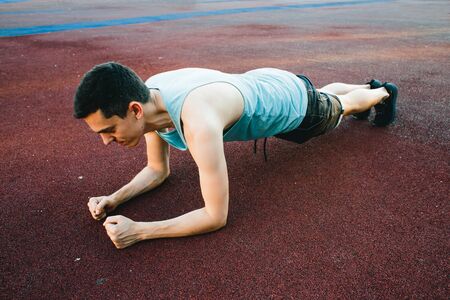 Young man doing outdoor exercise in new York. She is wearing a blue top and sport shortsの写真素材