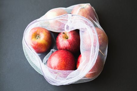 Reusable eco-friendly bag full of fresh seasonal apples. Caring for the environment and the rejection of plastic conceptの写真素材