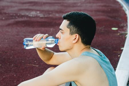 Young man doing outdoor exercise in new York. he is wearing a blue top and sport shortsの写真素材