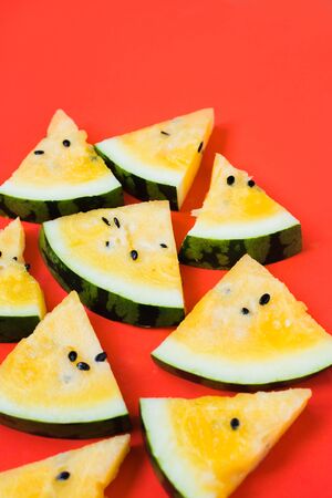 ripe yellow watermelon on red background, summer foodの写真素材