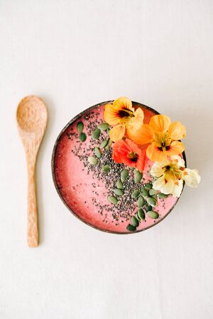 Breakfast in a plate of coconut with nasturtium flowers, Chia seeds and pumpkin seedsの写真素材