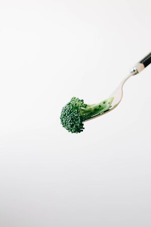 a fork with a green inflorescence of fresh broccoliの写真素材