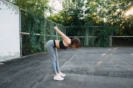 a young pretty girl on the Playground in sportswear does physical exercises.の写真素材