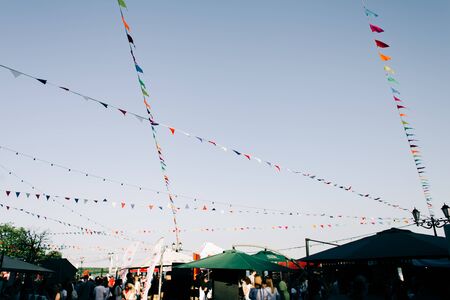 multicolored flags flutter in the wind over a street fair, decoration