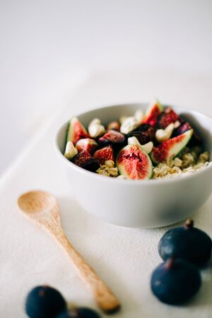 healthy Breakfast oatmeal with figs and cashews on a white table. vegan food Healthy eating.の写真素材