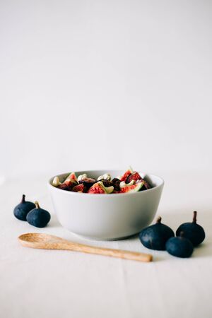 healthy Breakfast oatmeal with figs and cashews on a white table. vegan food Healthy eating.の写真素材