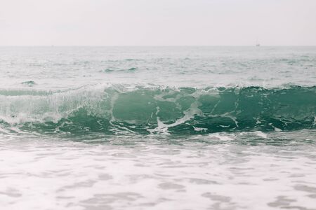 the sea wave arrives on the sandy shore .の写真素材