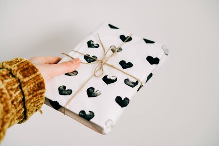a gift in homemade wrapping paper with black hearts for Valentine's dayの写真素材