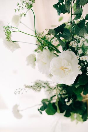 beautiful floral arrangement of delicate rose flowers and fresh greenery in the design of the wedding tableの写真素材