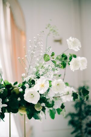 floral decoration of wedding tables, delicate white flowers and branches of fresh greeneryの写真素材