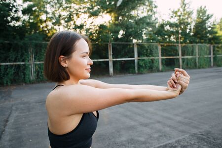 young attractive girl in sportswear on the Playground doing sports exercises in the summerの写真素材