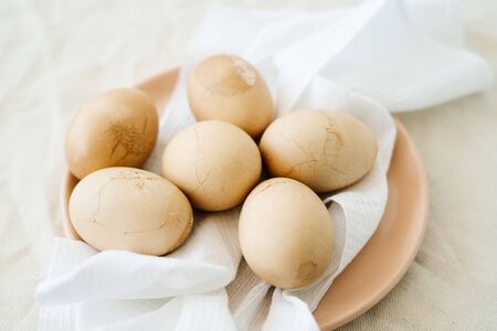 Six Easter eggs trendy pastel colored with cracked shells on a white napkin in a powdery plate. minimal style. Ester concept.の写真素材