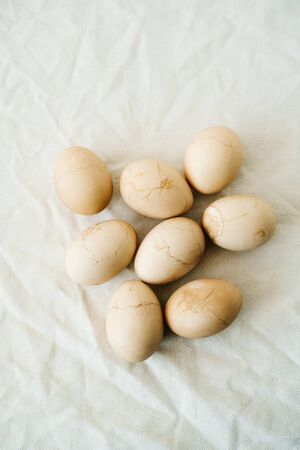Seven Easter eggs trendy pastel colored with cracks lie on the table on a light tablecloth. top view. minimal style. easter conceptの写真素材