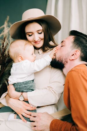 a beautiful young family of three. happy Father and mother hold their little son in their arms....