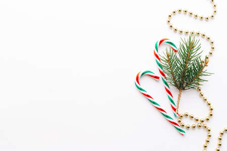 Christmas frame. Christmas balloons, garlands, red and gold decorations, Christmas candies and fir branches on a white background. Flat lay, top view, copy space.の写真素材