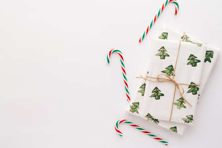Christmas composition. Gifts, red and green Christmas candy, decorations on a white background. The concept of Christmas, winter, New year. Flat stacking, top view, copy space.の写真素材