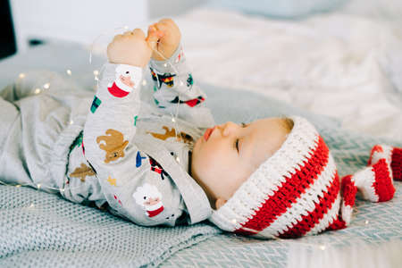 the child's first Christmas. a cute little boy in a Santa hat. lying on the bed. the view from the top. Christmas concept.の写真素材