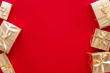 Red Christmas or new year's background, plain composition of golden Christmas gifts. Flatlay, empty...