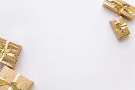 White Christmas or new year's background, plain composition of golden Christmas gifts. Flatlay,...