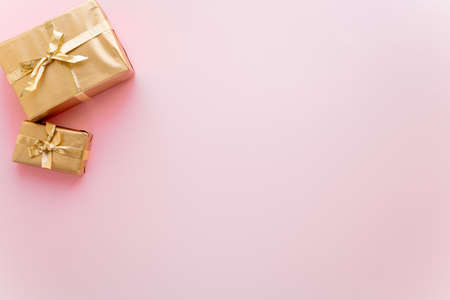 Pink Christmas or new years background, plain composition of golden Christmas gifts. Flatlay, empty space for greeting text.christmas concept.の写真素材