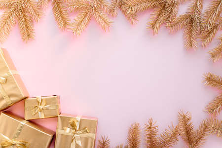 Pink Christmas or new years background,plain composition of golden Christmas gifts and golden fir branches, Flatlay,empty space for greeting text.christmas concept.の写真素材