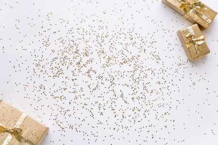 white Christmas or new years background, plain composition of golden Christmas gifts with golden...