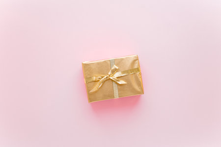 Pink Christmas or new years background, plain composition of golden Christmas gifts. Flatlay, empty space for greeting text.christmas concept.の写真素材