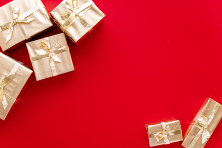 Red Christmas or new years background, plain composition of golden Christmas gifts. Flatlay, empty space for greeting text.christmas concept.の写真素材