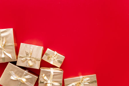 Red Christmas or new years background, plain composition of golden Christmas gifts. Flatlay, empty space for greeting text.christmas concept.の写真素材