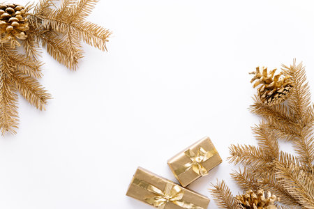 White Christmas or new year background,simple composition of Golden Christmas gifts,Golden fir branches and Golden pine cones,Flatlay,empty space for greeting text.の写真素材