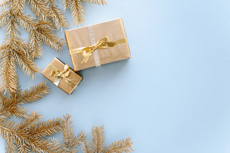 Blue Christmas or new year's background, plain composition of golden Christmas gifts and golden fir branches, Flatlay, empty space for greeting text.christmas conceptの写真素材