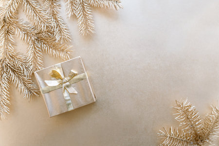 Golden Christmas or new year's background, plain composition of golden Christmas gifts and golden fir branches, Flatlay, empty space for greeting text.の写真素材