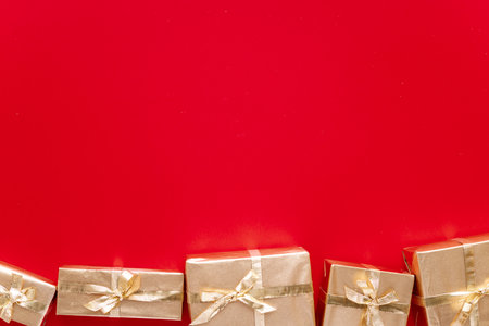 Red Christmas or new year's background, plain composition of golden Christmas gifts. Flatlay, empty space for greeting text.christmas conceptの写真素材