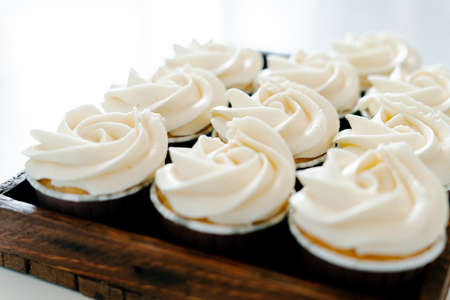 freshly baked cupcakes with strawberry-berry filling and white cream cheese on a wooden tray.Food for breakfast. Freshly baked cupcakes for dessert.の写真素材