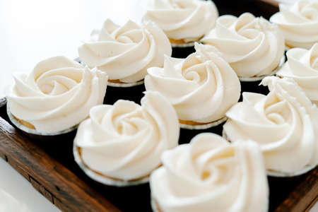 freshly baked cupcakes with strawberry-berry filling and white cream cheese on a wooden tray.Food for breakfast. Freshly baked cupcakes for dessert.の写真素材