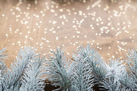 natural branches of the Christmas tree on a natural wooden table with shiny gold starsの写真素材
