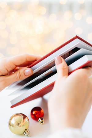 a red book in the hands of a young girl against the background of gifts and Christmas toys, a garland bokeh. the concept of Christmas. High quality photoの写真素材