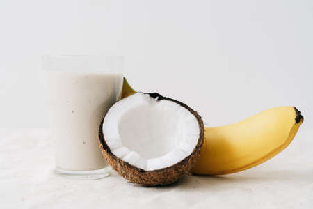 white healthy smoothie made of banana and fresh coconut, in a glass glass. healthy breakfast, healthy lifestyleの写真素材